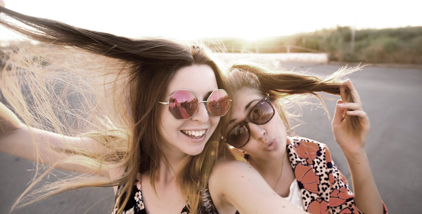 Two teen girls smiling outdoors