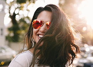 Smiling woman wearing red sunglasses