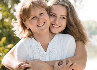 Smiling mother and daughter outdoors