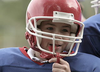 Young boy with football helmet and red mouthguard
